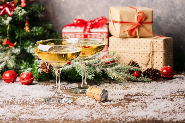 Champagne dans deux verres élégants sur une table de Noël festive avec des cadeaux un arbre de Noël décoré. Concept Nouvel An . — Photo