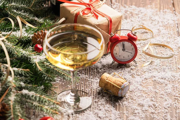 A glass of champagne sparkling wine cork clock close-up on a festive decorated table. Christmas New Year concept.