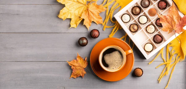 Cup of black coffee box of chocolates on an autumn background. Selective focus. Copy space. Top view flat layout.