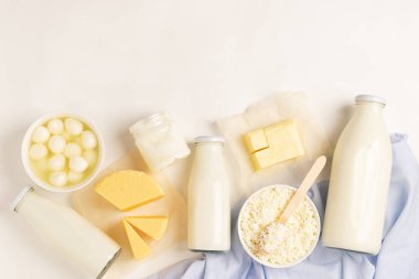 Süt ürünleri ve süt ürünleri beyaz arka planda. Süt, kefir, yoğurt, tereyağı, peynir çeşitleri. Düz görünüm üst görünümü.