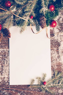 Siyah ahşap arka planda ladin noel ağacı oyuncaklarından oluşan temiz bir yaprak. Şenlikli Noel konsepti.