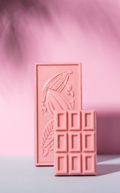 Pastel arka planda, çikolata pembesi fayanslar jest ışığı koyu gölge desenleri. Yiyecek kavramı minimalizmdir. Uzayı dikey olarak kopyala