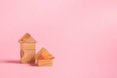 Çocuk tahta oyuncaklar pembe arka plan konsepti sıfır batı. Tasarımcının renk küpleri geliştirdiği küçük evler