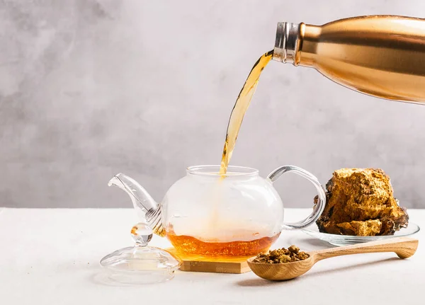 Wellness té curativo de abedul chaga setas se vierte desde un termo en una tetera de vidrio. Bebida orgánica antioxidante — Foto de Stock