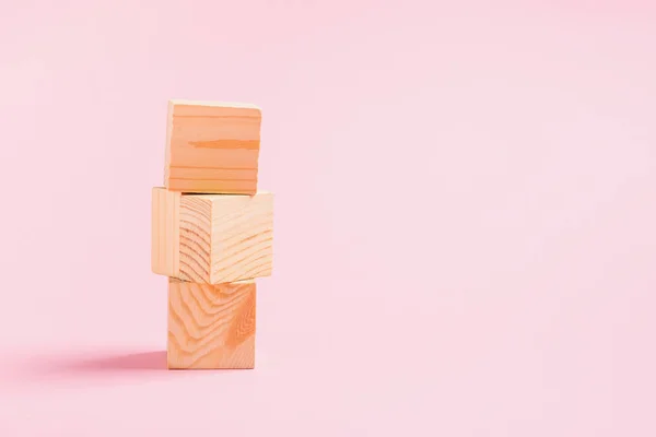 Tower of wooden cubes on a pink background. Childrens toys from natural materials concept zero West. Horizontal frame — 스톡 사진