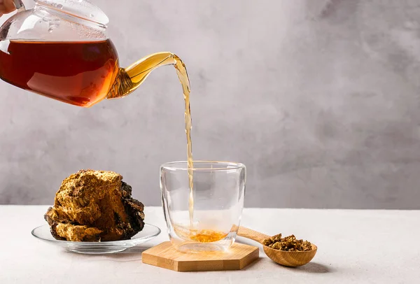 Concepto de comida saludable. Bebidas de comida de moda. Medicinal útil té de bosque kombucha vertido de tetera en taza de vidrio . — Foto de Stock