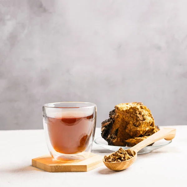 Concepto de comida saludable. Bebidas de comida de moda. Té medicinal saludable de setas de bosque en taza de vidrio en la mesa de la cocina . — Foto de Stock