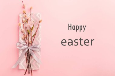 Söğüt dalları saten bir kurdeleyle bağlanmış şenlik örtüleri pastel pembe metinde bir kurdele ile Mutlu Paskalyalar. Şenlikli bahar konsepti.