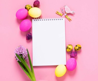 Mutlu Paskalyalar. Yumurtaların şenlikli bahar yerleşimi pembe arka planda temiz defter çiçekleri. Boşluğu kopyala.