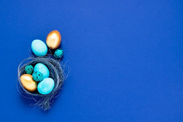 Joyeux concept de Pâques. Composition printanière festive petits gros œufs bleus dans un nid sur un fond minimaliste à la mode . — Photo