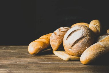 Altın hamurlu taze ekmek, somun, çörek, beyaz, rustik ahşap arka planda çavdar ekmeği. Yatay çerçeve