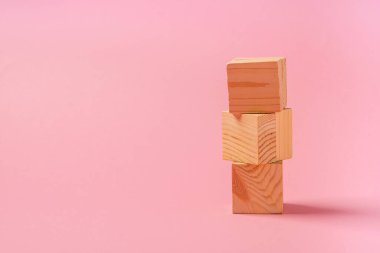 Pembe arka planda tahta küplerden bir kule. Sıfır Batı konseptindeki çocuk oyuncakları. Yatay çerçeve