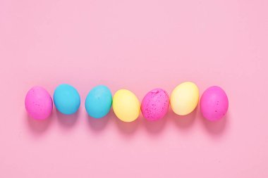 Mutlu Paskalyalar. Pembe arka planda renkli yumurtalar. Uzay düzlemini kopyala. Reklam için yeri olan pankart.