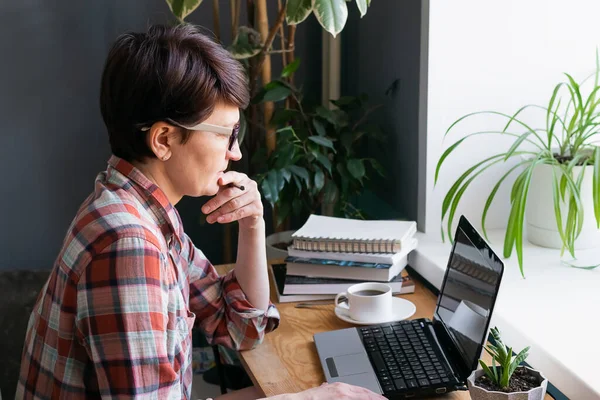 The concept of distance work or online learning during the quarantine virus. Woman works on a digital laptop at home,