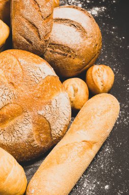 Üzerinde altın hamuru, somun ekmeği, çörekler, beyaz, rustik ahşap bir arka planda çavdar ekmeği. Düz Düzen