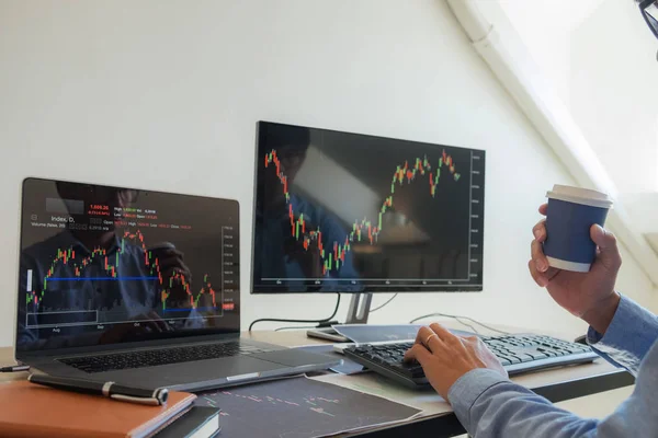 Trading on the table is working on a computer screen full of cha — Stock Photo, Image