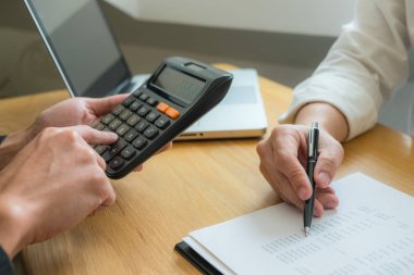 Bank employees sit and work and check the financial summary