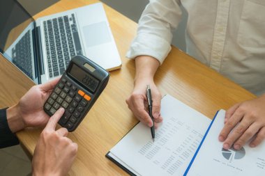 Bank employees sit and work and check the financial summary
