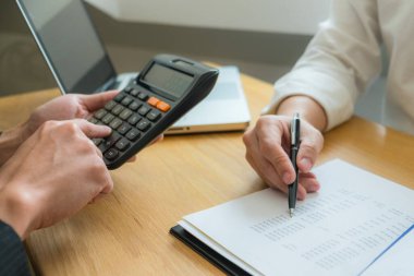 Bank employees sit and work and check the financial summary