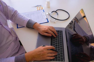 Doktor masaya oturdu, çalıştı, hastanın belgelerini kontrol etti.