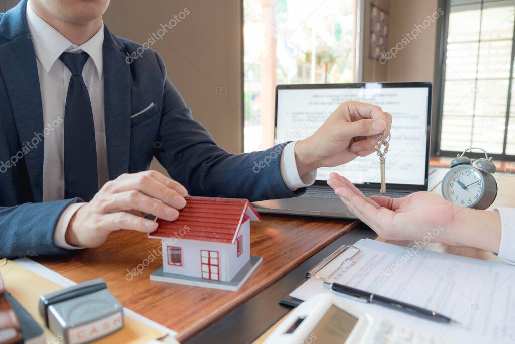 Handing over your house keys after making a mortgage contract, buying a home successfully, and becoming a home owner.