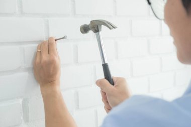 Tamirci mobilyaları el kitabına göre ve mekanik ekipmanlarla birlikte evde monte etti. Çivileri çekiçle çakarak mezura ile ölçerek vida delme deliklerini vidalayarak.
