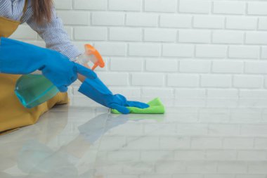 Temizlik ekibi yüzeyde giysiler kullanıyor ve virüsleri ve hastalıkları öldürmek için içerikli temizlik maddeleri kullanıyor..