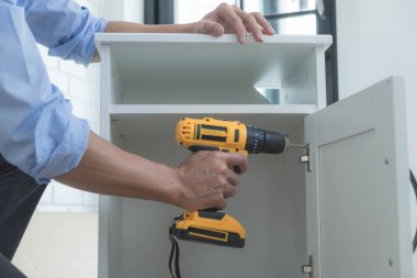 Tamirci mobilyaları el kitabına göre ve mekanik ekipmanlarla birlikte evde monte etti. Çivileri çekiçle çakarak mezura ile ölçerek vida delme deliklerini vidalayarak.