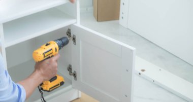 Tamirci mobilyaları el kitabına göre ve mekanik ekipmanlarla birlikte evde monte etti. Çivileri çekiçle çakarak mezura ile ölçerek vida delme deliklerini vidalayarak.