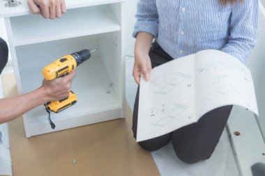 Tamirci mobilyaları el kitabına göre ve mekanik ekipmanlarla birlikte evde monte etti. Çivileri çekiçle çakarak mezura ile ölçerek vida delme deliklerini vidalayarak.