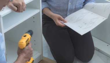 Tamirci mobilyaları el kitabına göre ve mekanik ekipmanlarla birlikte evde monte etti. Çivileri çekiçle çakarak mezura ile ölçerek vida delme deliklerini vidalayarak.