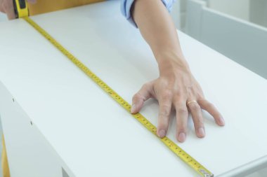 Tamirci mobilyaları el kitabına göre ve mekanik ekipmanlarla birlikte evde monte etti. Çivileri çekiçle çakarak mezura ile ölçerek vida delme deliklerini vidalayarak.