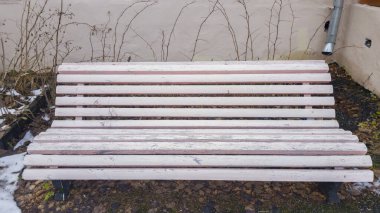 Yeşil çimenlerin ve beyaz karın arka planında çok renkli tahtalardan oluşan sokak bankı