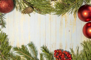 Noel ve Yeni Yıl arkaplanlarında ışık var. Taze ladin dalı ve çıkıntıları. Kırmızı çelenkler. Boşluğu kopyala