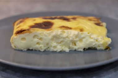 Gri tabakta nefis yumurta ve peynir güveci.