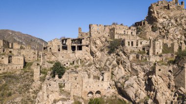 Şehir - hayalet, Dağıstan, Rusya - 1 Eylül 2019: Antik kalıntılar şehri, şehir - hayalet, arka plan kayalar üzerinde yeşil bitki örtüsü ile dağlık alan, mavi gökyüzü ve yeşil orman