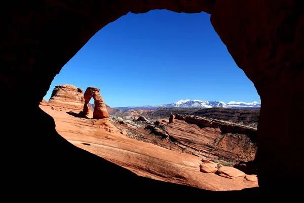 アーチの世界的に有名な繊細なアーチ国立公園 アメリカ晴れた日に澄んだ青い空で 洞窟から撮影 — ストック写真