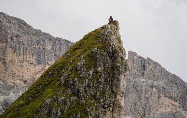 Dik kayanın tepesinde mutlu yürüyüşçü. Zirveye başarıyla ulaştı.