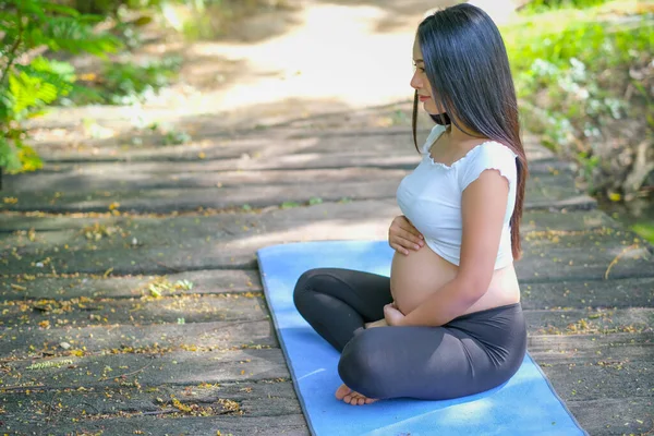 Młoda Azjatka Ciąży Dotykać Jej Brzuch Patrzeć Przodu Siedzieć Niebieskiej — Zdjęcie stockowe