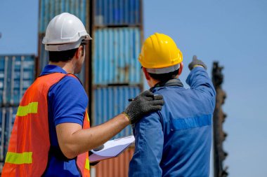 Mühendis ve teknisyen, kargo konteynır bölgesindeki ürün ve sistemin kalitesini kontrol etmek için birlikte yardım ediyor..