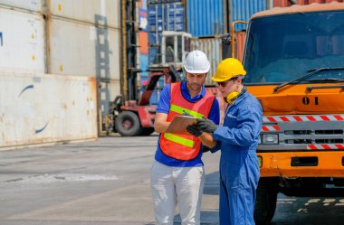 Teknisyen ve mühendis kargo konteynır bölgesinde kalite ve ürün kontrolü için birlikte çalışıyorlar..