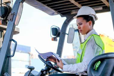 Afrikalı teknisyen kadın traktörü takip ediyor ve işini nasıl yapacağını düşünüyor..