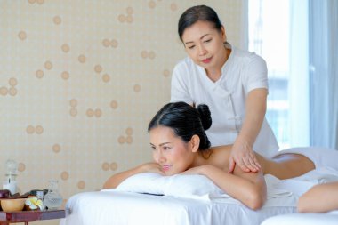 Genç Asyalı güzel kız için Tayland masajı. Spa odasında gün ışığıyla yatar..