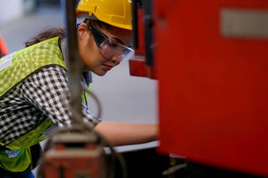 Güzel Asyalı işçi ya da teknisyen kadın fabrikadaki makine sorununu çözdü.