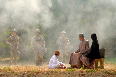 Müslüman ailenin yumuşak bulanıklığı köyün yakınındaki savaş sırasında ormandan gelen bir grup askere bakıyor..
