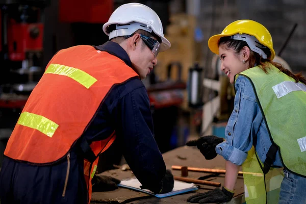 技術者や労働者の男性と女性は 幸せな感情を持つ工場での彼らの仕事について議論することで一緒に働く — ストック写真
