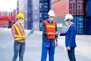 Müdür, konteynır işyerindeki personel listesini ya da personel kaydını tutarken teknisyen ya da mühendis işçiye el salladı. Yeni normal yaşam tarzının covid virüs enfeksiyonunu önlemek için prosedür.