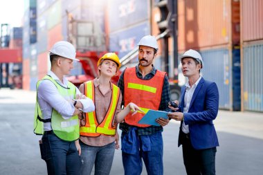 Bir grup teknisyen ya da mühendis birlikte kargo nakliyat işyerindeki işlerini tartışıyorlar. İyi bir takım çalışması ve sistem ile kavram daha iyi endüstriyel işleri desteklemeye yardımcı olur.