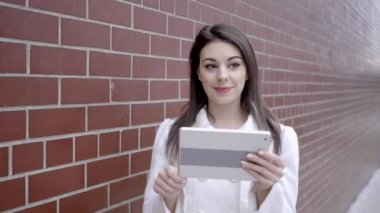 sokakta duran ve tablet bilgisayarı kullanan kadın