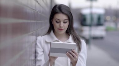 sokakta duran ve tablet bilgisayarı kullanan kadın